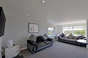 a living room with two couches and a tv at Foxwood in Kenwyn