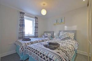 a bedroom with two beds and a window at Foxwood in Kenwyn