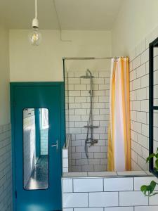 a bathroom with a shower with a blue door at Fritto Misto Comune Stays in Fabriano