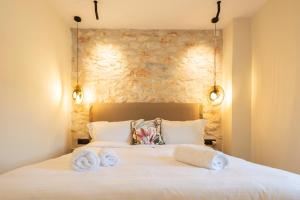 a bedroom with a bed with towels on it at Paradise Can Wait Sophia Suites in Areopoli