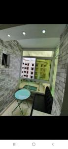 a view of a living room with a table and a window at Appartement à côté la plage in Oulad Akkou