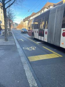 a bus driving down a street with a bike lane at Frya Fribourg Studio in Fribourg +2 photos