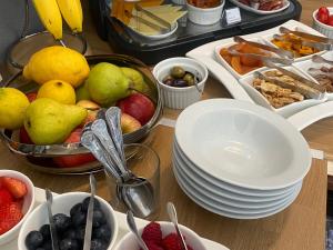 a table topped with plates and bowls of fruit at Tyndale Boutique B&B - Adults Only in Torquay