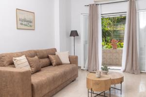 un salon avec un canapé marron et une table dans l'établissement Casa Thalia, Kanoni, Corfu, à Kanoni