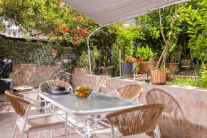 une table et des chaises sur une terrasse avec des plantes dans l'établissement Casa Thalia, Kanoni, Corfu, à Kanoni