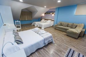sypialnia z łóżkiem i salon z kanapą w obiekcie Albergue Arribada w mieście Muxia +18 zdjęć