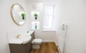 Un baño con lavabo, inodoro y espejo. en Stylish 3-Bed Apartment in the Heritage Quarter, en Dunfermline