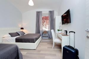 ein Schlafzimmer mit einem Bett und einem Schreibtisch mit einem Koffer in der Unterkunft St. Peter Vatican House in Rom