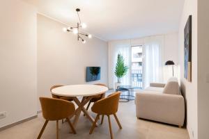 a living room with a table and chairs and a couch at RELSTAY - De Angeli in Milan