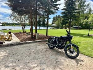 a motorcycle parked in a park next to a lake at Rybakówka Marina Restaurant in Sokole-Kuźnica +31 photos