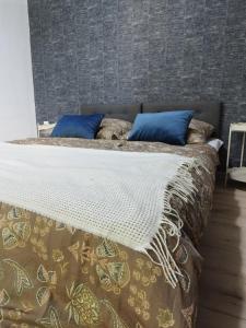 a large bed with blue pillows on top of it at Apartament Warszawska Centrum in Mrągowo +4 photos