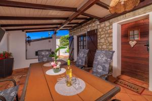 a dining room with a wooden table and chairs at Bobbys Home in Selce