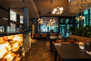 un ristorante con tavoli, sedie e un camino di Stegna Deluxe Amber Apartments a Stegna