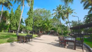a park with tables and chairs and palm trees at Lancaster Accra in Accra