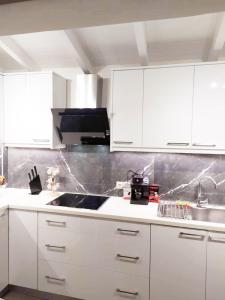 a kitchen with white cabinets and a sink at Luxury mini villas AA in Kríni