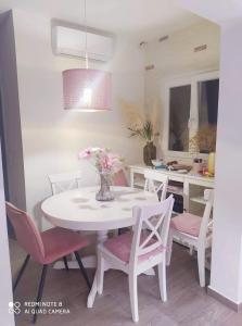 a white table and chairs with a vase of flowers at Luxury mini villas AA in Kríni