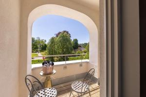 a balcony with chairs and a table with a bottle of wine at Hotel Villa Hirzel in Schwäbisch Gmünd +6 photos