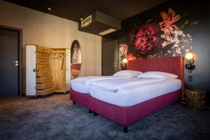 a bedroom with a large bed and a painting on the wall at Hotel Villa Hirzel in Schwäbisch Gmünd