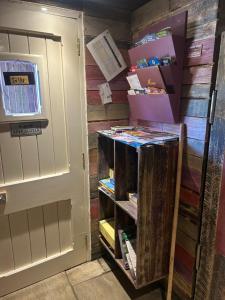 un estante de libros junto a una puerta con libros en Rhodes To Serenity - Waterfall Shepherds Hut, en Cauldon