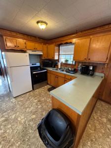 a kitchen with wooden cabinets and a white refrigerator at The Miss Ella Houseboat 