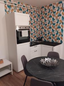 a small kitchen with a table and a microwave at Apartmani Venium in Križevci