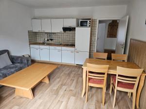 a kitchen and living room with a wooden table and chairs at Ferienwohnung Seegat Nr 4 in Norden