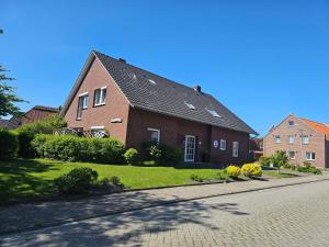 a large red brick house on a street at Ferienwohnung Seegat Nr 4 in Norden