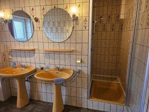 a bathroom with two sinks and a shower at Ferienwohnung Seegat Nr 4 in Norden