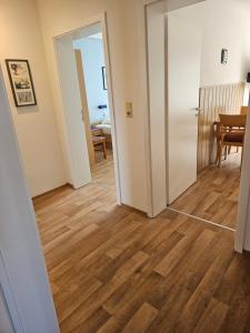 a hallway with an open door and a dining room at Ferienwohnung Seegat Nr 4 in Norden +2 photos