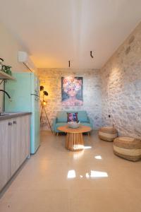 a living room with a blue couch and a table at Paradise Can Wait Sophia Suites in Areopolis +49 photos