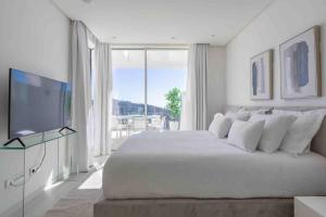 a white bedroom with a large bed and a large window at 812 ALM Luxury aparment in Palo Alto, Marbella in Ojén