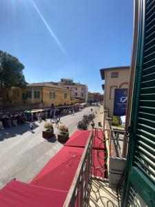 a view of a street with a red table on a balcony at Maison Odette in Pisa