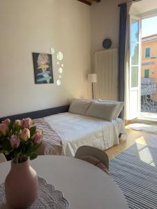 a bedroom with a bed and a table with a vase of flowers at Maison Odette in Pisa +27 photos