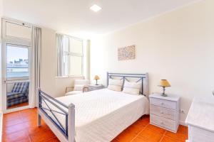 ein weißes Schlafzimmer mit einem Bett und einem Fenster in der Unterkunft Holiday Praia da Rocha in Strand Praia da Rocha + 15 Fotos