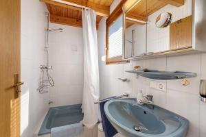 a bathroom with a blue sink and a tub at Schwalbennest in Bodman-Ludwigshafen +20 photos