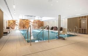 a swimming pool in a hotel lobby with a stone wall at perfect vacation in Eilat - סוויטת בוטיק מעוצבת לחופשה מושלמת באילת במתחם U360 in Eilat