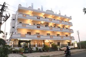 Un gran edificio con un hombre en una motocicleta al frente. en Posh Hotel-Best Business Hotel in Gulbarga, en Gulbarga