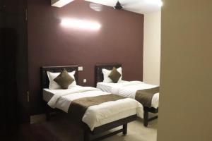 1 dormitorio con 2 camas con sábanas blancas y paredes marrones en Posh Hotel-Best Business Hotel in Gulbarga, en Gulbarga 25 fotos más
