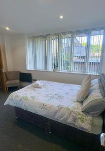 a large bed in a room with windows at Spacious 2 Bedroom Flat City Centre in Cannock