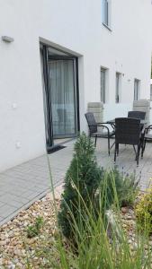 a patio with two chairs and a table in front of a building at Apartmán POD ROTUNDOU in Skalica
