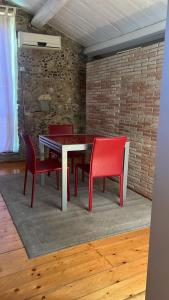 Marano MarchesatoにあるIl Casaleのダイニングルーム(テーブル、赤い椅子付)
