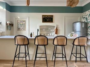 a kitchen with three bar stools in front of a counter at NEW Iron Gates - Central Frome in Frome +13 photos