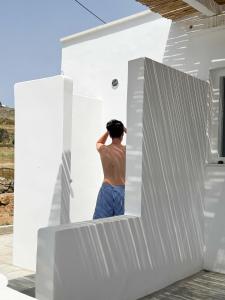 a man is standing in the doorway of a white house at Maira's house in Agios Sostis