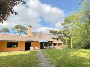 a house with a patio and a grass yard at Le Grand Hôtel Le Touquet-Paris-Plage in Le Touquet-Paris-Plage