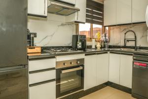 a kitchen with white cabinets and a stove top oven at Luxury golf Prestigia Saphir in Marrakech