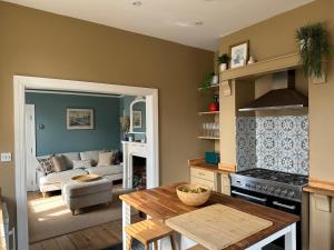 a kitchen with a table and a living room at NEW Victorian Residence - sleeps 12 in Frome