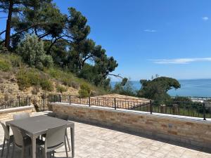 a table and chairs on a patio overlooking the ocean at Villa Colle dei Pini in Cupra Marittima