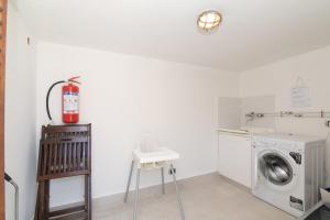 a laundry room with a washing machine and a stool at San Teodoro Villa Nina Costa Caddu in San Teodoro