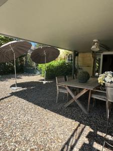 ファルケンブルグにあるVakantie appartement Villa Dianaのピクニックテーブル、パティオ(傘2本付)