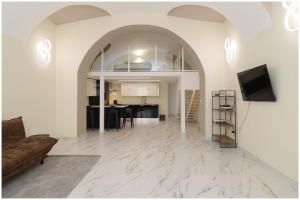 an open living room with a couch and a tv at Piave X Design Loft Quadrilatero WiFi AC in Turin